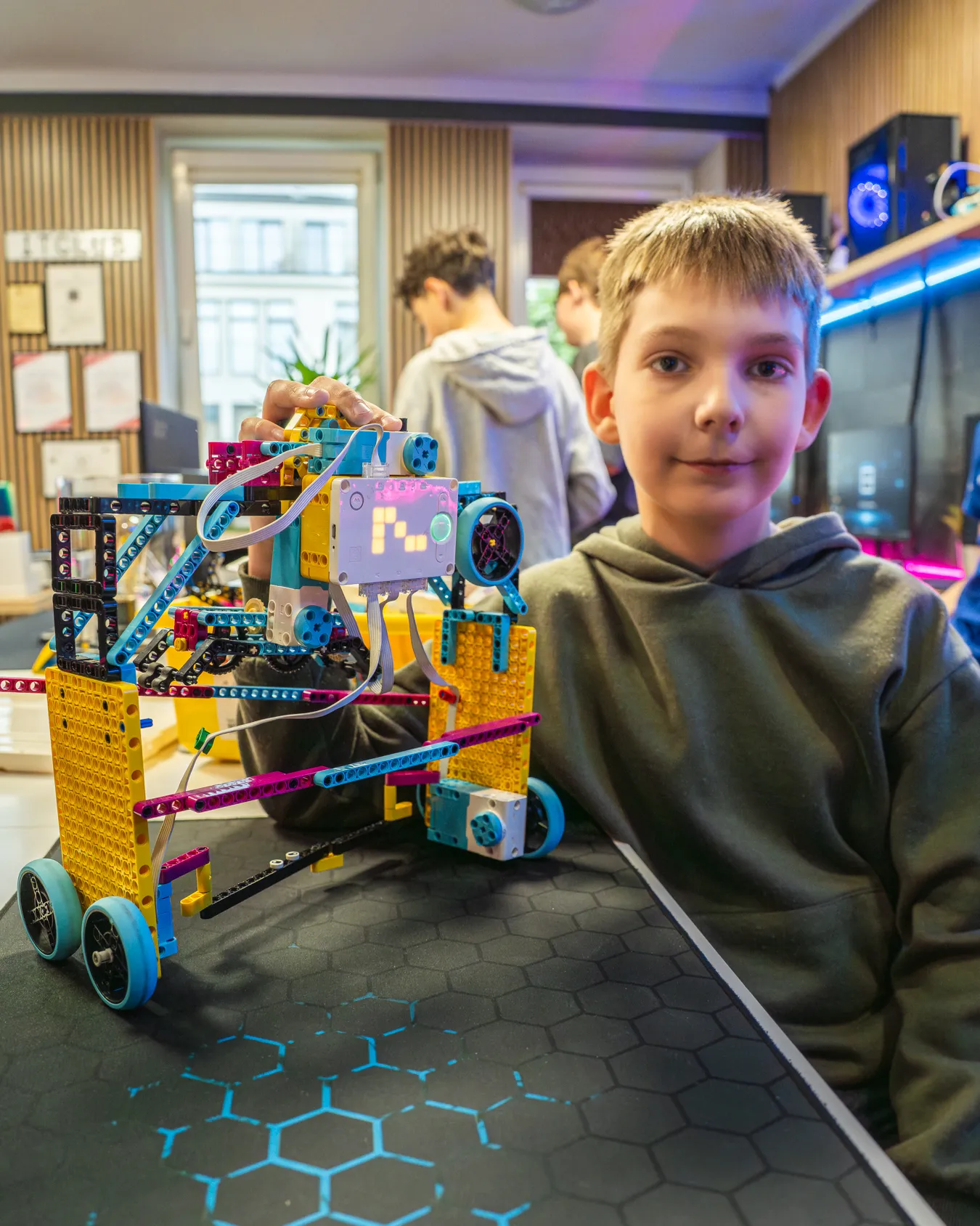 Uczeń prezentuje własnego robota LEGO po praktycznym teście mechanizmu